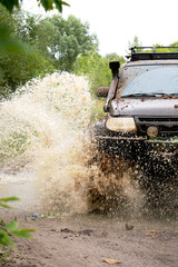 off-road car driving through a puddle, a lot of spray, dirt © Екатерина Ваулина