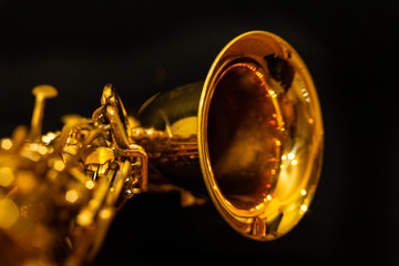 Saxofón dorado apoyado fondo negro