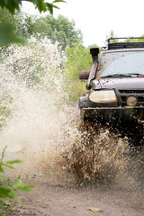 off-road car driving through a puddle, a lot of spray, dirt © Екатерина Ваулина