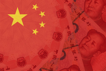 China national flag overlaid with Yuan renminbi banknotes. Chinese money and political situation....