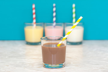 Chocolate milkshake in front of a row of flavoured milkshakes