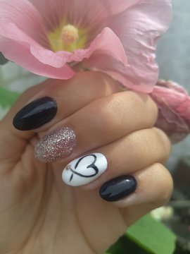  Manicure in black and white color with a heart on a nameless in a romantic style. Hand nails