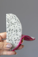 Cropped view of woman hand holding a piece of pitaya