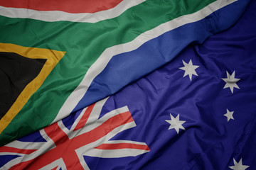 waving colorful flag of australia and national flag of south africa.