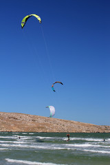 Kitesurfing on the waves of the sea. Panoramic view of people practicing kitesurf