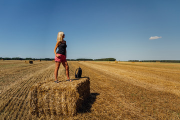 Portrait of  beauty blonde caucasian woman standing on redneck of straw with backpack - obrazy, fototapety, plakaty