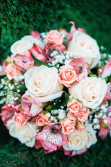 Close-up photo of wedding bouquet lying on green grass.