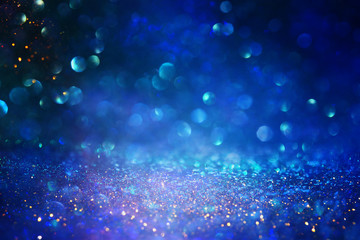blackground of abstract glitter lights. blue, gold and black. de focused