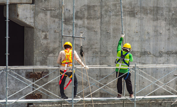 Construction worker wearing safety work at high uniform on scaffolding at construction site