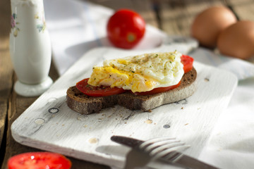 Poached egg on sourdough toast, with grilled tomatoes. A healthy, delicious breakfast or brunch