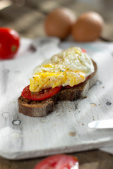 Poached egg on sourdough toast, with grilled tomatoes. A healthy, delicious breakfast or brunch