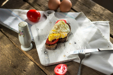 Poached egg on sourdough toast, with grilled tomatoes. A healthy, delicious breakfast or brunch