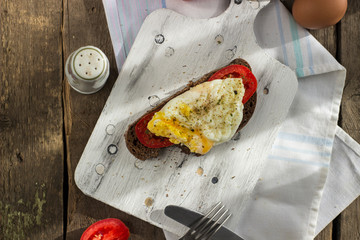 Poached egg on sourdough toast, with grilled tomatoes. A healthy, delicious breakfast or brunch