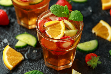 Refreshing Pimms Cocktail with Fruit and vegetables on rustic black table