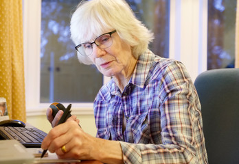 Senior old elderly person learning computer and online pension and banking internet skills protect against fraud uk