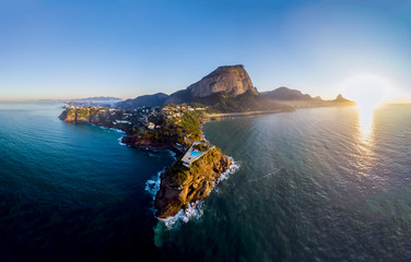 Panoramic view of the coastline and beach of Joatinga in Rio de Janeiro with its beautiful picturesque natural richness and far in the background the well known landmark peaks of the city