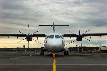 Close Up Front of turboprop Airplane or Aeroplane Parked at Airport. Modern passenger twin-engine turboprop airplane.