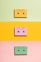 Painted audio cassettes on bright multicolor background, copy space, top view. Retro musical background