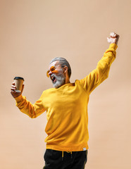 Smiling bearded hipster man holding plastic cup.