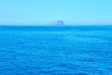 Rocky island in the middle of the sea. Natural background texture. Copy space.