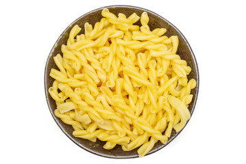 Lot of whole raw pasta gemelli on grey ceramic plate flatlay isolated on white background