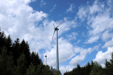 Fototapeta na wymiar Wind turbines and trees in a forest - Stockphoto
