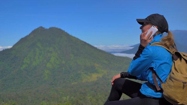The traveler use a mobile phonr in the mountain range