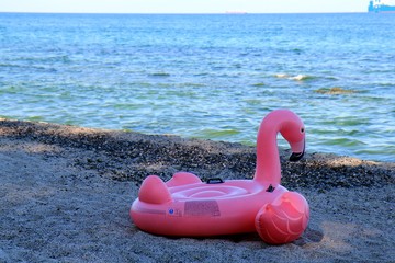 Inflatable mattress in the form of pink Flamingo on the black sea