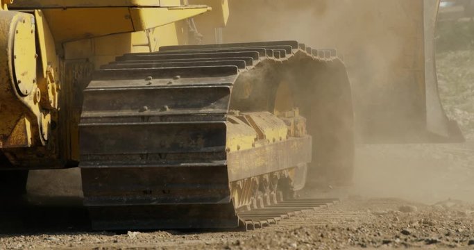 Close up of heavy duty bulldozer travelling in reverse.