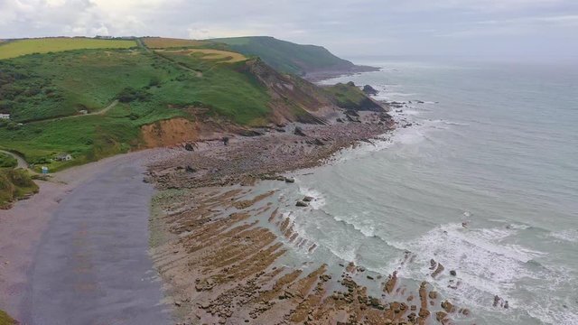 Aerial dolly in shot of coastal rock formations in Widemouth Bay, Cornwall.