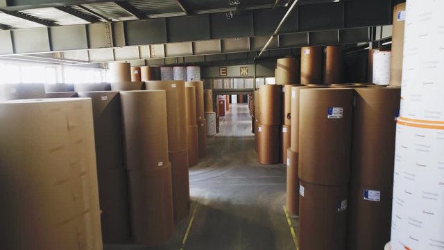 motion along pass between paper rolls in factory storage