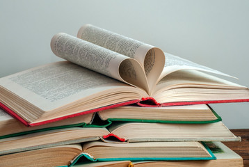 Old, used hardback books. Education. The heart is folded from the pages of the book.