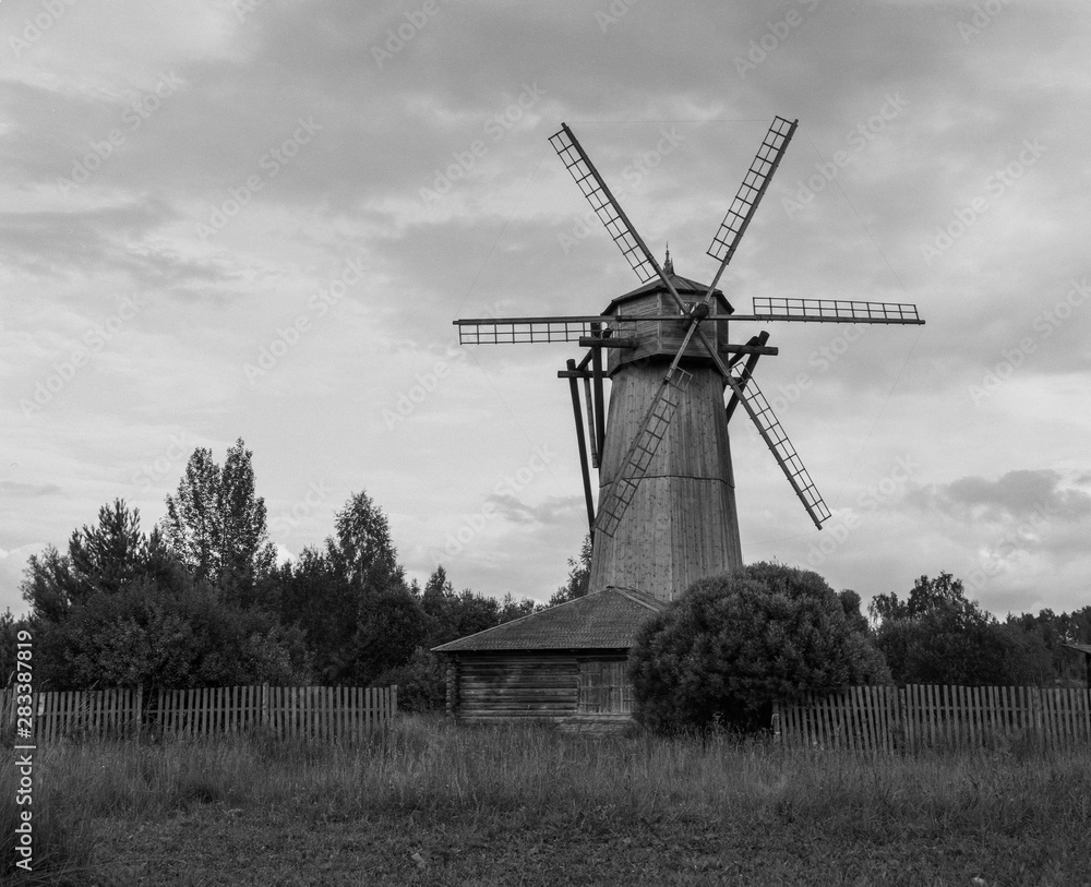 Wall mural monochrome film photography of old wooden windmill in rural landscape