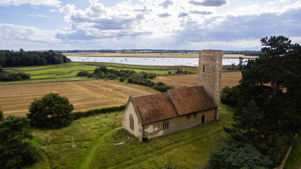 An aerial photo of Ramsholt church. A beautiful traditional church with a round tower located in the beautiful Suffolk countryside close to the River Deben