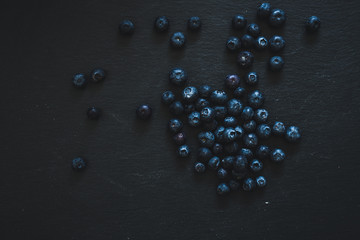 Group of blueberries placed on the middle of a black background - Small dark berries full of antioxidants for vegetarian diet