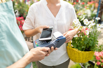 Garden center client using contactless payment app to pay for fresh flowers