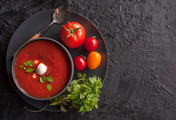 Summer cold tomato vegetable soup Gazpacho on the black table. Vegetarian cuisine. Copy space. The...