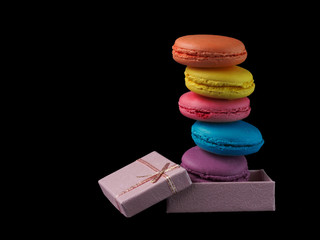 Macaroons box top view. Sweet french macaroons cake on the black background.