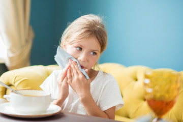 Beautiful child girl wipes her mouth with napkin in cafe restaurant