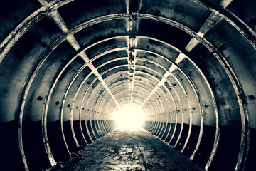 Abstraction for the background. Tunnel with annular rigid ribs and bright light at the end....