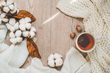 Background with warm sweaters and cup tea. Cozy still life in warm shades, space for text, Autumn winter concept. Copy Space.