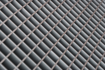 Abstract blurred diagonal lattice background from metal. Gray tint.