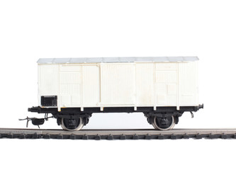 Model of a steam locomotive and cistern on rails on a white background
