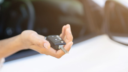 close up driver chauffeur adult man hand holding car's key and showing outside window for safety and insurance concept