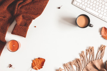 Autumn composition. Cup of coffee, sweater, plaid, autumn leaves on white background. Flat lay, top view, copy space