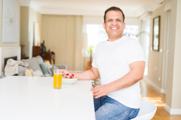 Middle age arab man eating cereals at breakfast with happy face