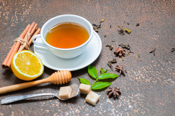 Closeup of cup of tea and herb on grunge dirty background
