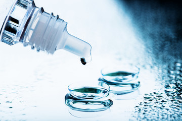 Bottle with lens solution and case on table..