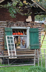 Hütte in den Bergen mit einem Fenster mit Kürbissen und  Zwiebeln