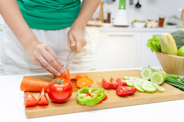 Cooking. young pretty woman in green shirt cutting cooking and knife preparing fresh vegetables salad for good healthy in kitchen at home, healthy lifestyle, cooking, healthy food and dieting concept